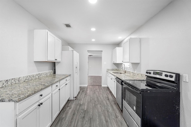 kitchen with visible vents, light wood-style flooring, a sink, stainless steel appliances, and white cabinets