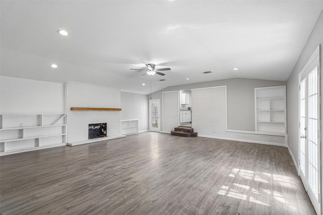 unfurnished living room featuring visible vents, a fireplace with raised hearth, dark wood finished floors, ceiling fan, and vaulted ceiling