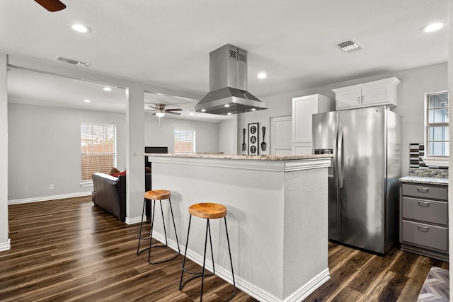 kitchen featuring a center island, visible vents, white cabinets, island range hood, and stainless steel fridge with ice dispenser