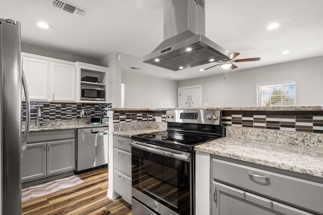 kitchen featuring island range hood, white cabinets, dark wood finished floors, stainless steel appliances, and backsplash