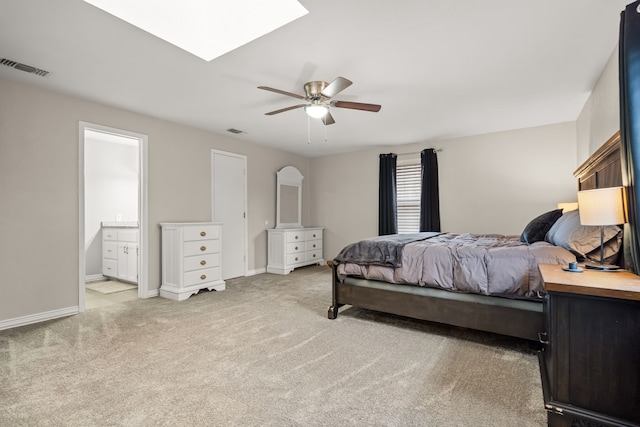 bedroom featuring a skylight, baseboards, visible vents, and light colored carpet