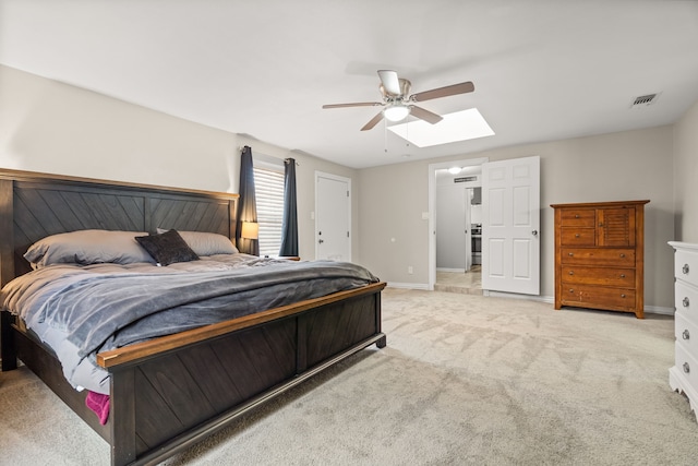 bedroom featuring light carpet, a skylight, visible vents, and baseboards