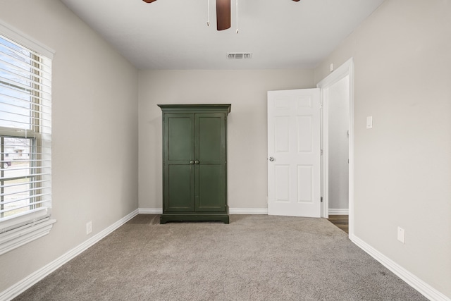 unfurnished bedroom featuring carpet, visible vents, and baseboards