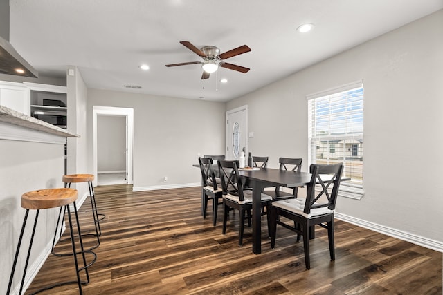 dining room with dark wood-style floors, visible vents, and baseboards