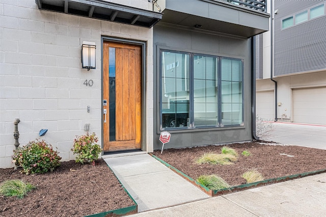 entrance to property with driveway and concrete block siding