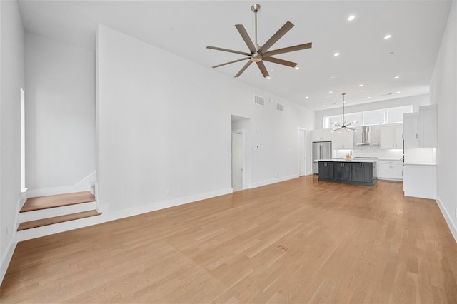 3200 Ross Ave Unit 40, Dallas, TX 75204 - unfurnished living room featuring ceiling fan, a chandelier, light wood finished floors, recessed lighting, and baseboards