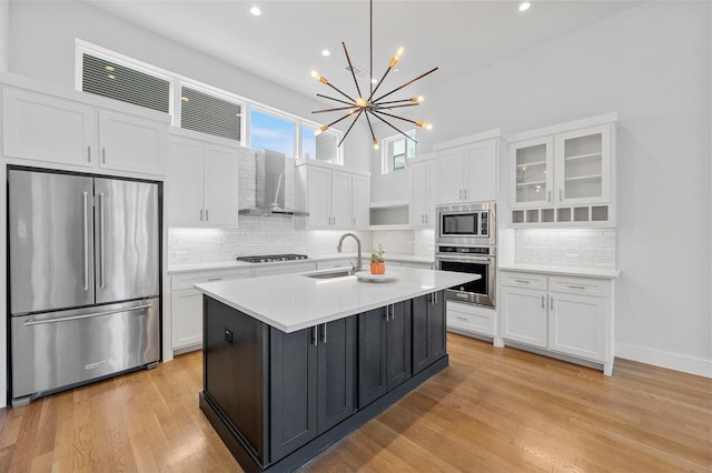 3200 Ross Ave Unit 40, Dallas, TX 75204 - kitchen with stainless steel appliances, wall chimney range hood, white cabinets, light countertops, and backsplash