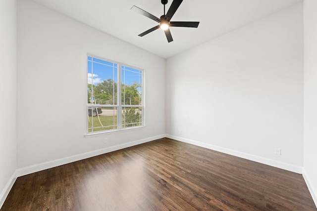 unfurnished room featuring dark wood finished floors, a ceiling fan, and baseboards