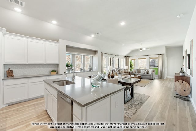 210 Shawnee Trl, Alvarado, TX 76009 - kitchen with stainless steel dishwasher, a kitchen island with sink, white cabinets, and a sink