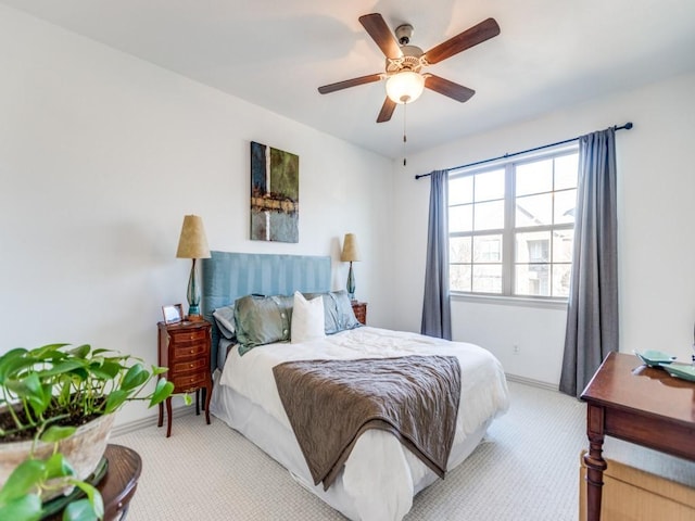 bedroom with baseboards, a ceiling fan, and light colored carpet