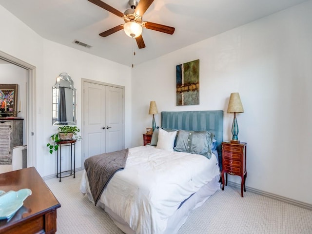 bedroom featuring a closet, visible vents, light carpet, ceiling fan, and baseboards