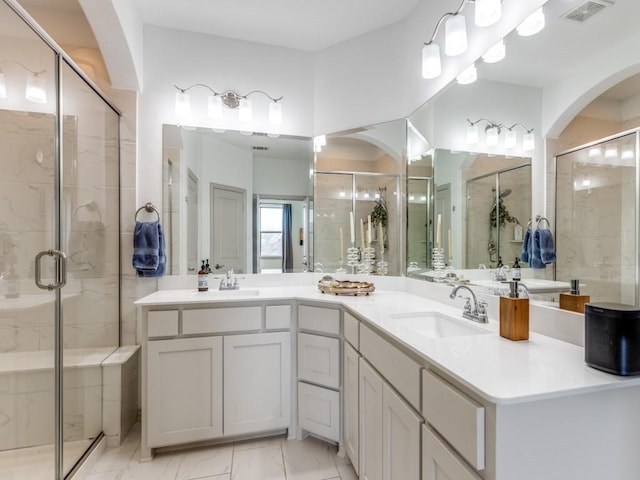 full bath featuring marble finish floor, a shower stall, visible vents, and a sink