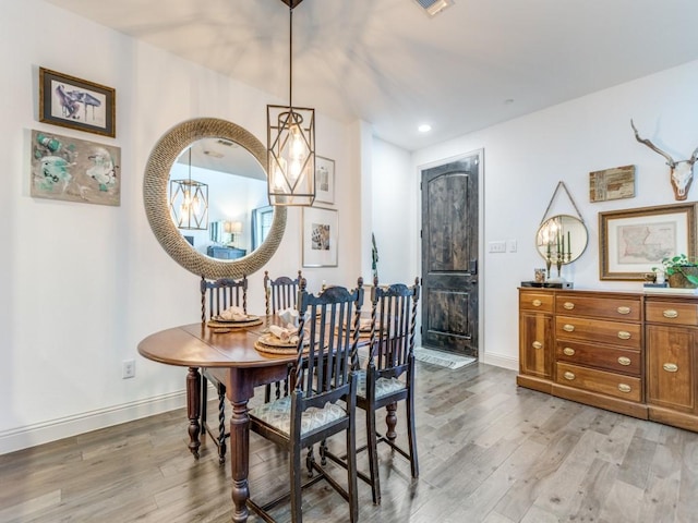 dining space with baseboards and light wood finished floors