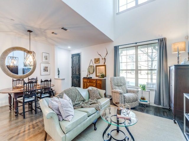 living room featuring visible vents, plenty of natural light, and wood finished floors