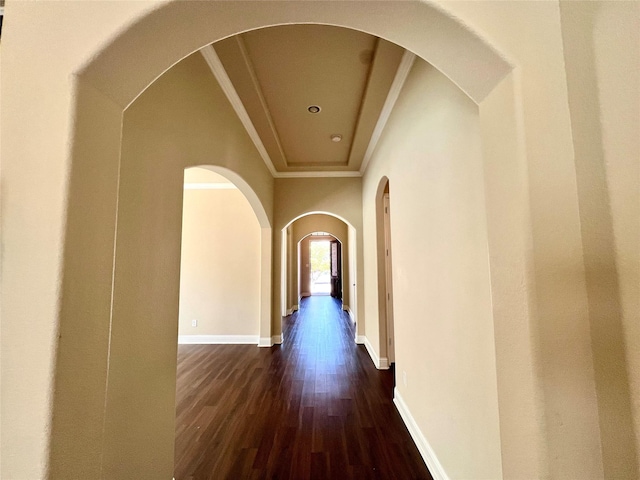 hall with baseboards, dark wood finished floors, and crown molding