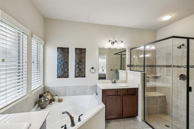 bathroom with a stall shower, tile patterned floors, vanity, and a bath