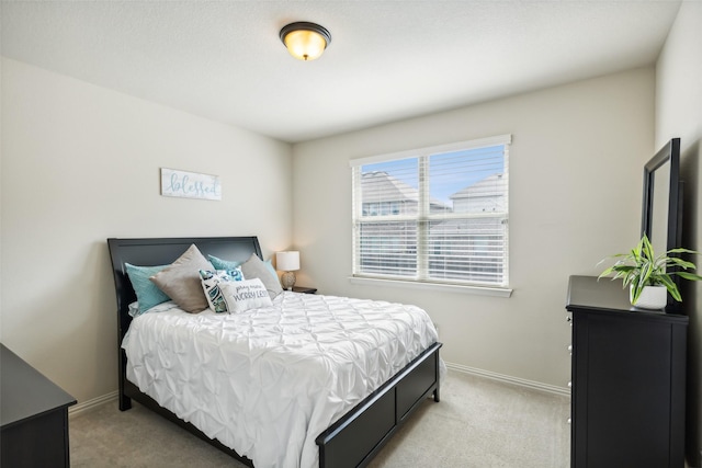 bedroom featuring light carpet and baseboards