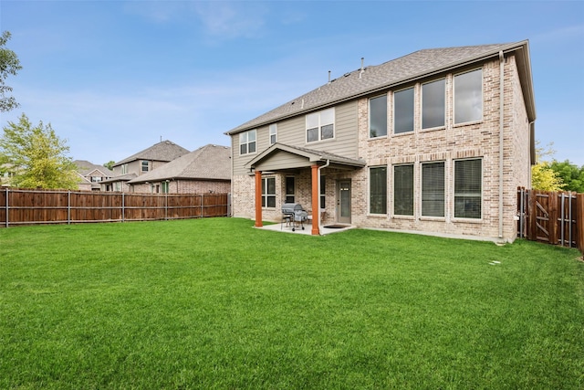 back of property featuring a patio area, a fenced backyard, brick siding, and a yard