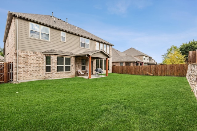 back of property featuring a patio, brick siding, a lawn, and a fenced backyard