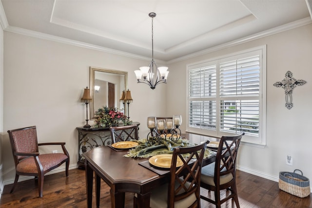 dining space with dark wood-style floors, a tray ceiling, a notable chandelier, and baseboards