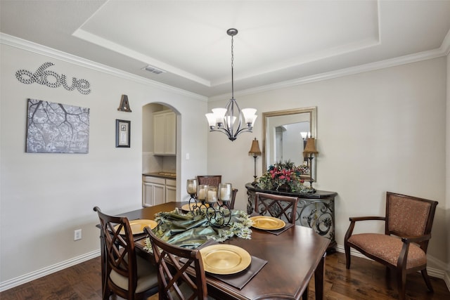 dining area with dark wood-type flooring, a raised ceiling, visible vents, and baseboards