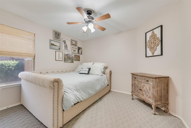 bedroom with light carpet, baseboards, and ceiling fan