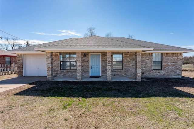 view of front of house featuring a garage, driveway, a shingled roof, and a front yard