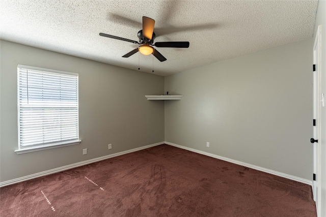 spare room featuring dark colored carpet, ceiling fan, a textured ceiling, and baseboards