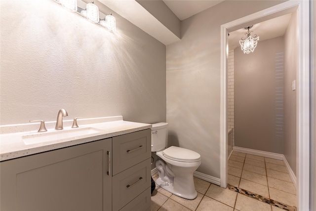 bathroom with toilet, tile patterned floors, vanity, baseboards, and a tub