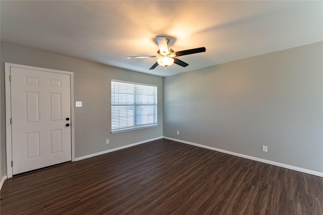 interior space with a ceiling fan, dark wood finished floors, and baseboards