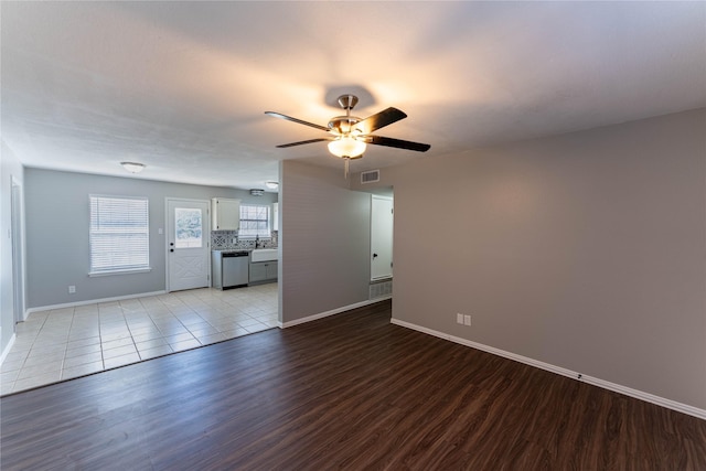 unfurnished living room with light wood-type flooring, baseboards, visible vents, and a ceiling fan