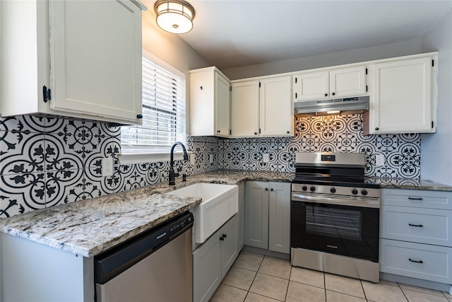 kitchen featuring white cabinets, under cabinet range hood, light stone counters, and stainless steel appliances