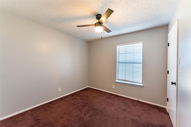 spare room featuring dark carpet, ceiling fan, a textured ceiling, and baseboards