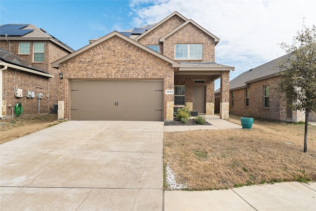 view of front facade with a front lawn, concrete driveway, brick siding, and an attached garage