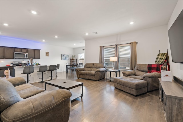 living area featuring recessed lighting, visible vents, and wood finished floors