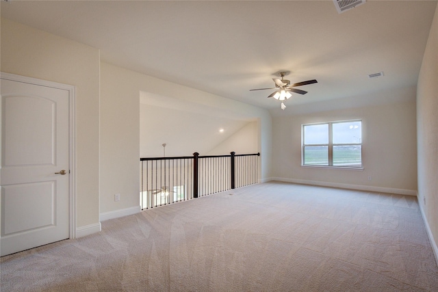 empty room with light carpet, ceiling fan, visible vents, and baseboards