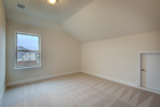 bonus room featuring baseboards, visible vents, vaulted ceiling, and light colored carpet