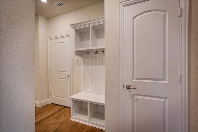 mudroom with a textured wall, wood finished floors, and visible vents