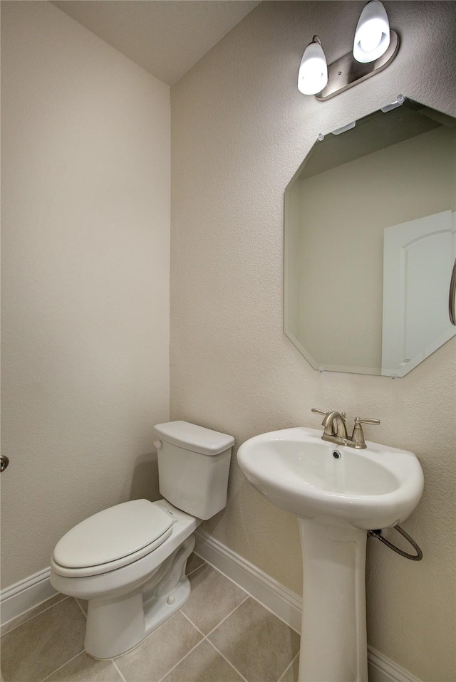 bathroom featuring baseboards, toilet, and tile patterned floors