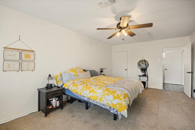 carpeted bedroom featuring baseboards, a ceiling fan, visible vents, and attic access