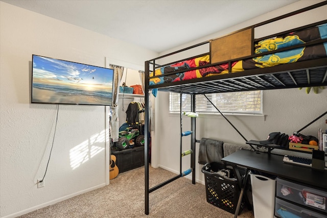 bedroom featuring carpet flooring, a textured wall, and baseboards