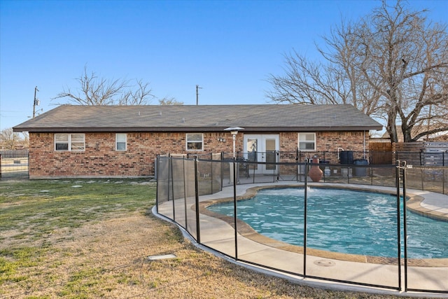 view of swimming pool featuring fence, french doors, a fenced in pool, and a yard