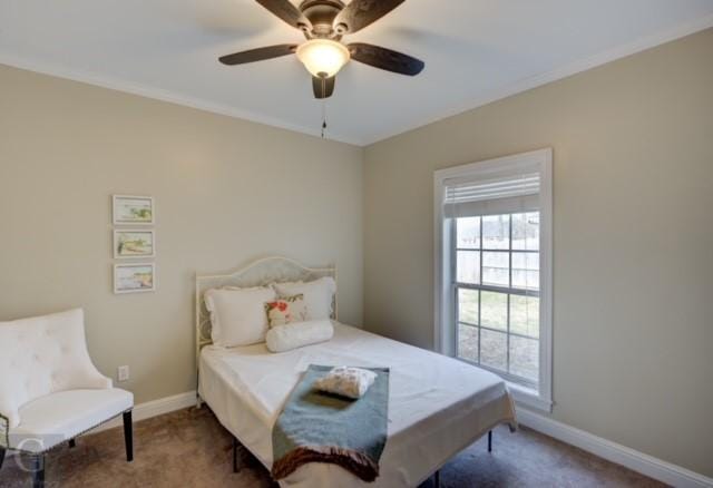 carpeted bedroom featuring crown molding, baseboards, and a ceiling fan