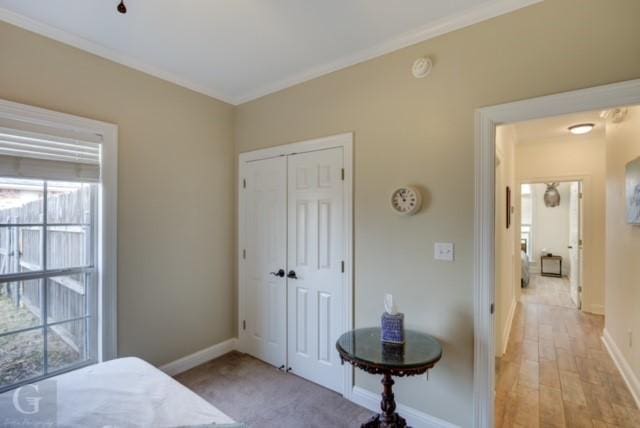 bedroom featuring crown molding, a closet, and baseboards