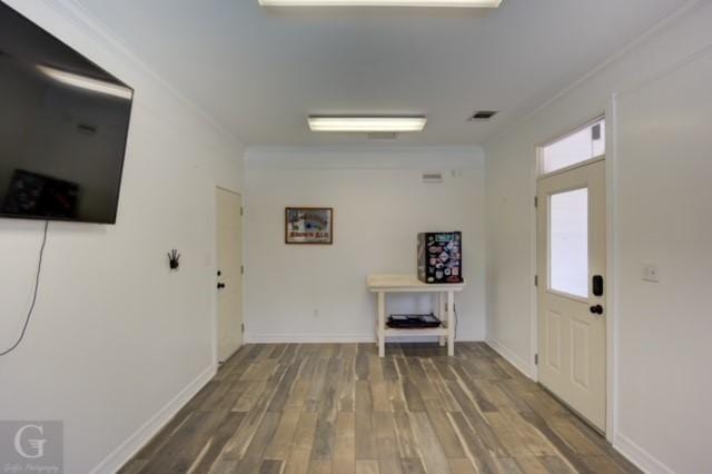 entrance foyer featuring visible vents, crown molding, baseboards, and wood finished floors