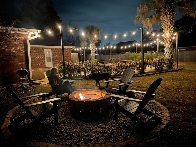 view of property's community with fence and a fire pit