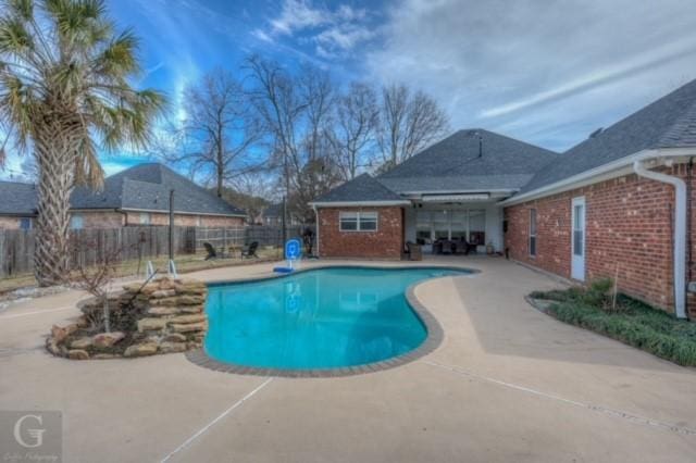 view of swimming pool featuring fence, a fenced in pool, and a patio