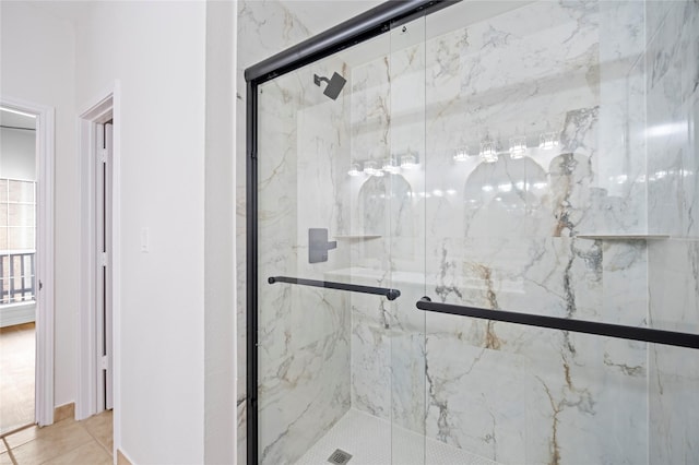 bathroom featuring a marble finish shower and tile patterned floors