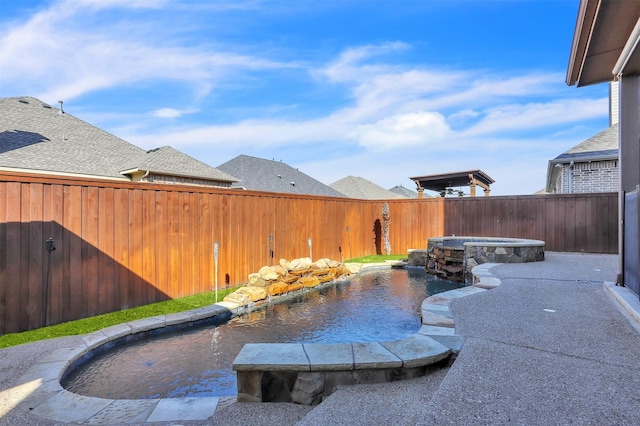 view of swimming pool with a fenced backyard and an in ground hot tub