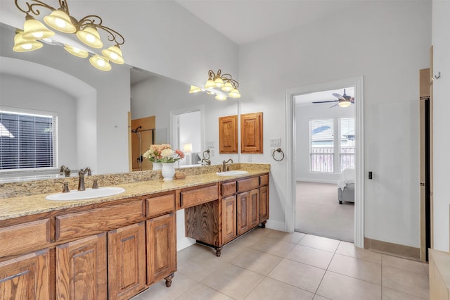 ensuite bathroom featuring double vanity, a sink, ensuite bath, and tile patterned floors